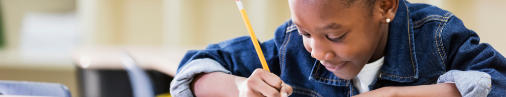 Young Black female student smiling while writing with a yellow pencil.