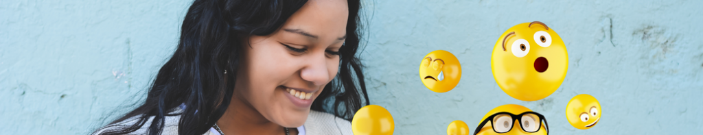 Female teen with dark wavy hair smiles down at her phone with various computer-generated emojis floating off the screen.