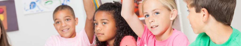 Diverse group of elementary students raise their hands to answer a question.