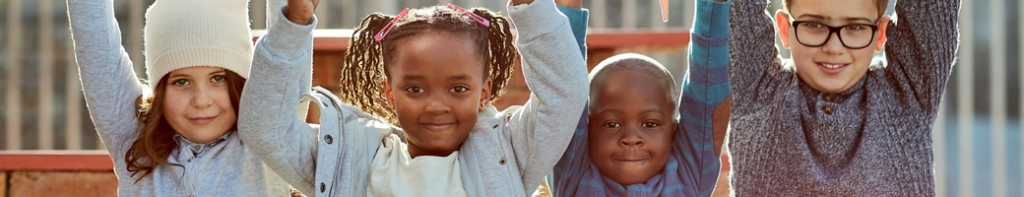 Diverse group of children with their arms stretched up in the air.