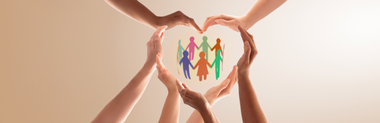 Multicolored paper cutout of people in the middle with hands of people first skin tones wrapping around to form the shape of a heart.