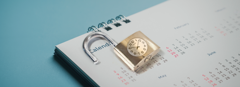 a lock with a clock on it unlocked on top of a calendar