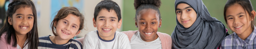 Diverse group of six middle school students smiling facing the camera.